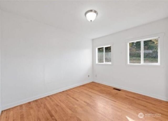 10601 55th Ave S, Seattle, WA 98178 - unfurnished room featuring visible vents, baseboards, and light wood-type flooring