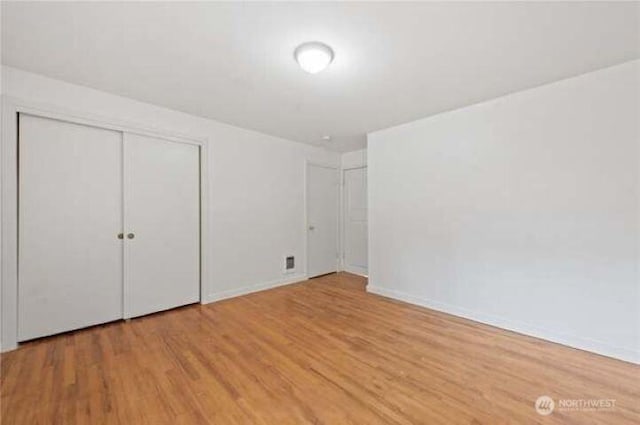 10601 55th Ave S, Seattle, WA 98178 - unfurnished bedroom featuring a closet, baseboards, and wood finished floors