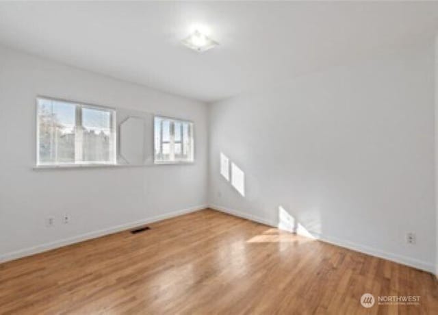 10601 55th Ave S, Seattle, WA 98178 - empty room featuring visible vents, baseboards, and wood finished floors