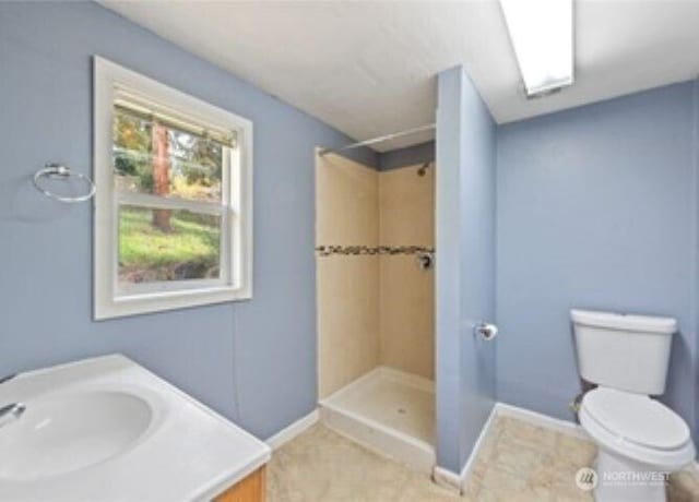 10601 55th Ave S, Seattle, WA 98178 - full bathroom with toilet, tiled shower, vanity, and baseboards