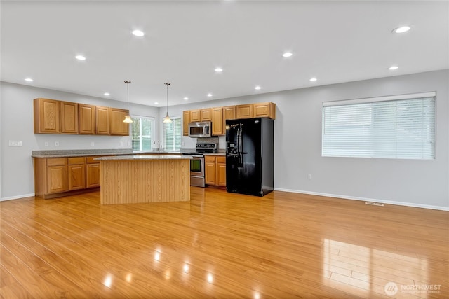 kitchen featuring a sink, a center island, stainless steel appliances, light wood-style floors, and recessed lighting