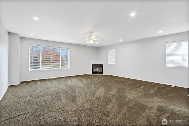 unfurnished living room featuring carpet flooring, recessed lighting, a healthy amount of sunlight, and ceiling fan