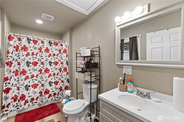 bathroom featuring toilet, wood finished floors, vanity, and a shower with curtain