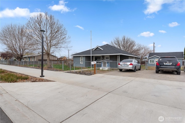 view of front of house featuring concrete driveway and a fenced front yard