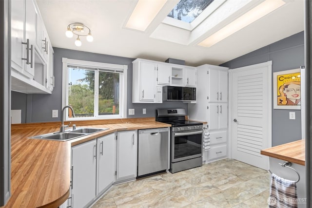 kitchen with open shelves, butcher block counters, white cabinets, stainless steel appliances, and a sink