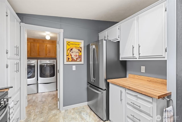 kitchen with stainless steel appliances, wood counters, washer and clothes dryer, and white cabinetry