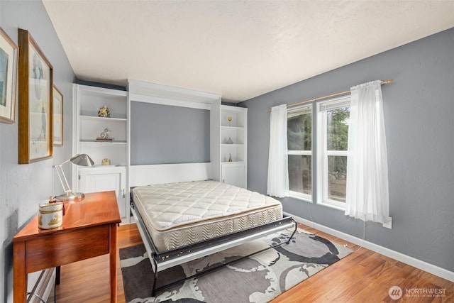 bedroom featuring baseboards and wood finished floors
