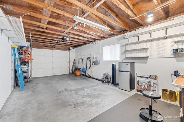 garage with a garage door opener and freestanding refrigerator