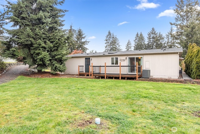 rear view of property with a deck, central AC unit, and a lawn