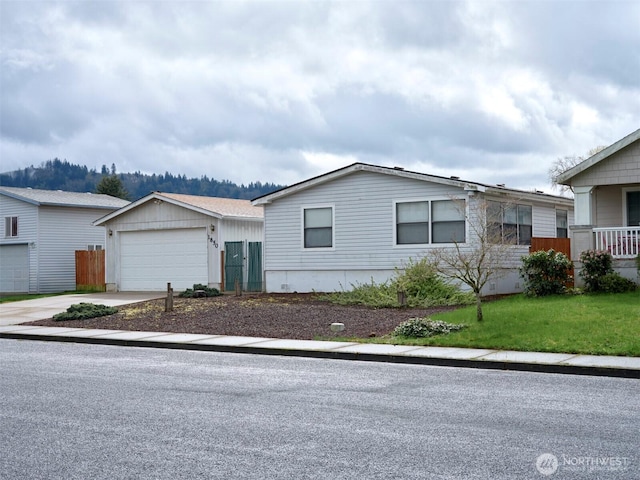 1850 Heartwood Dr, Woodland, WA 98674 - view of front of home with a front yard, an outbuilding, concrete driveway, and fence