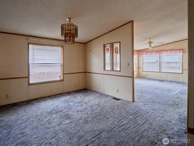 1850 Heartwood Dr, Woodland, WA 98674 - carpeted spare room with vaulted ceiling, a textured ceiling, ceiling fan with notable chandelier, visible vents, and ornamental molding