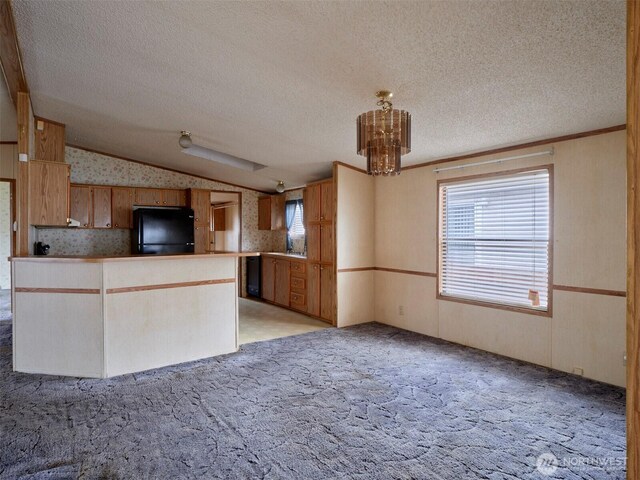 1850 Heartwood Dr, Woodland, WA 98674 - kitchen with lofted ceiling, black fridge, a chandelier, a textured ceiling, and wallpapered walls