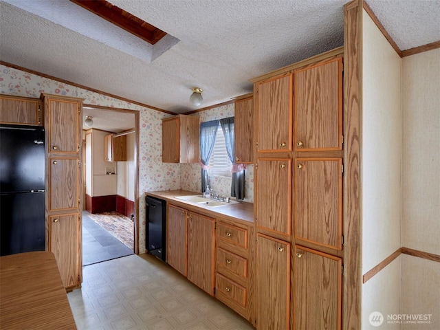 1850 Heartwood Dr, Woodland, WA 98674 - kitchen with a textured ceiling, wallpapered walls, light floors, a sink, and black appliances