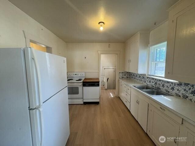 609 S 16th Ave, Yakima, WA 98902 - kitchen featuring white appliances, a sink, light wood-style floors, light countertops, and white cabinets