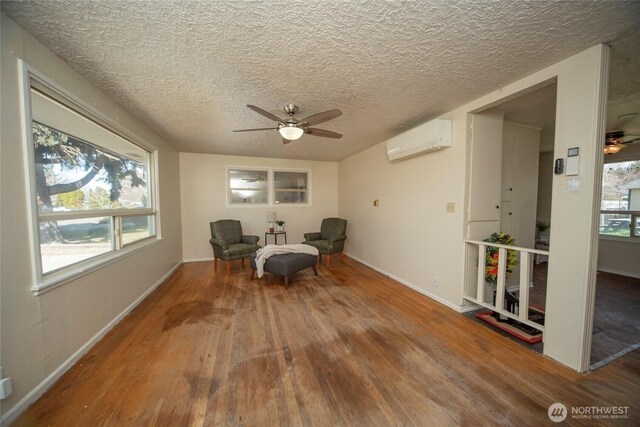 708 S Park Pl, Ellensburg, WA 98926 - unfurnished room with a ceiling fan, a wall mounted AC, baseboards, and wood finished floors