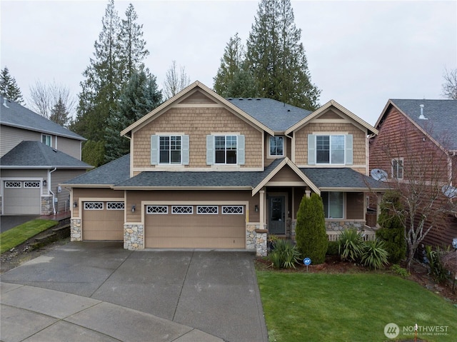 craftsman house featuring a front lawn, roof with shingles, stone siding, and concrete driveway