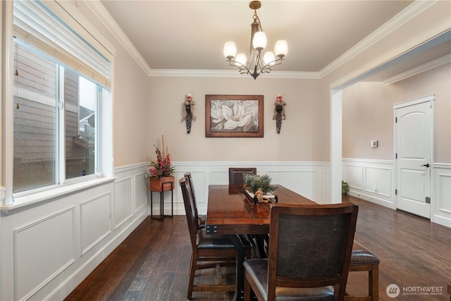 dining space featuring wainscoting, an inviting chandelier, crown molding, and dark wood finished floors