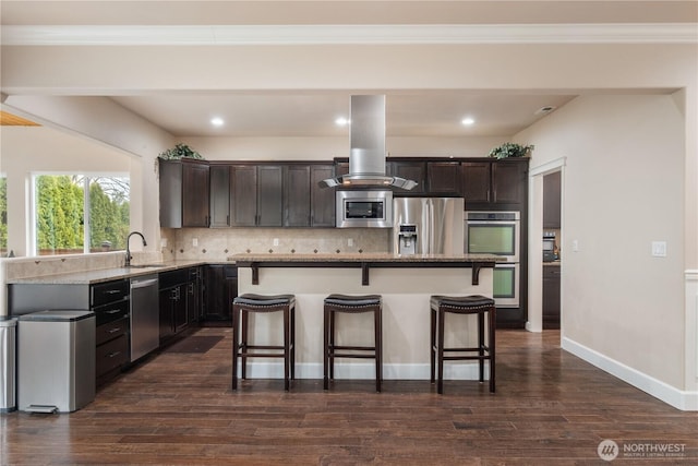 kitchen with decorative backsplash, island range hood, a kitchen breakfast bar, and appliances with stainless steel finishes