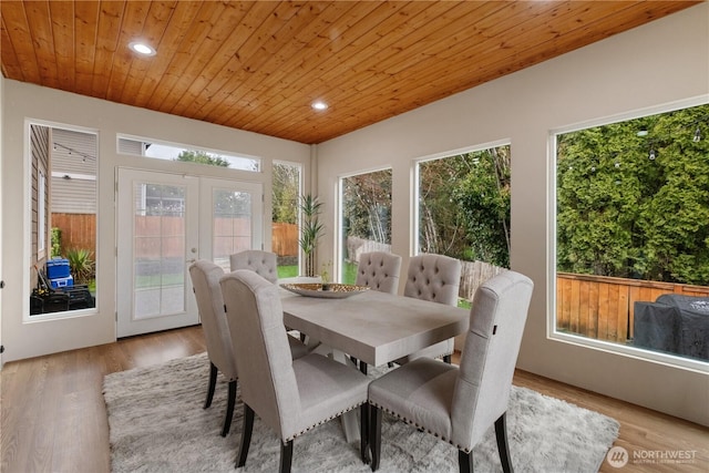 sunroom / solarium with wood finished floors, wooden ceiling, and french doors