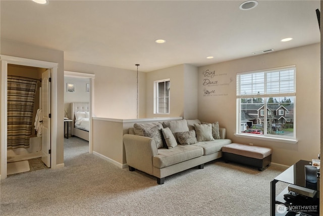 carpeted living area featuring baseboards, visible vents, and recessed lighting