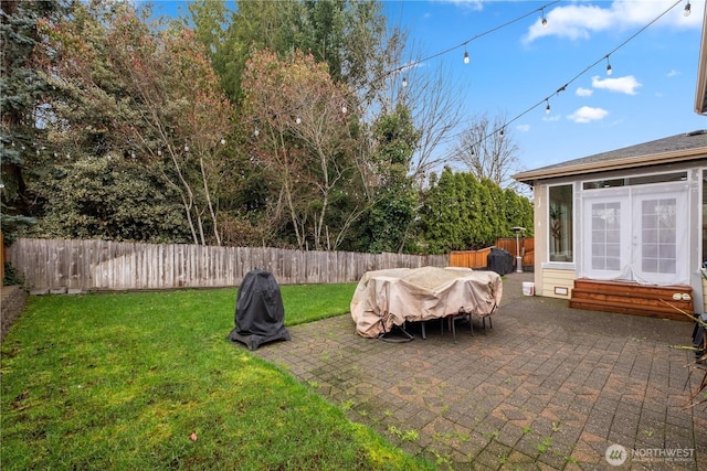view of yard featuring a fenced backyard, french doors, entry steps, and a patio area