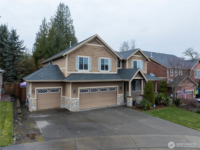 view of front of house featuring stone siding, a garage, driveway, and a shingled roof
