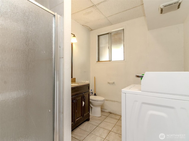 full bath featuring tile patterned floors, vanity, a shower stall, washer / dryer, and a drop ceiling