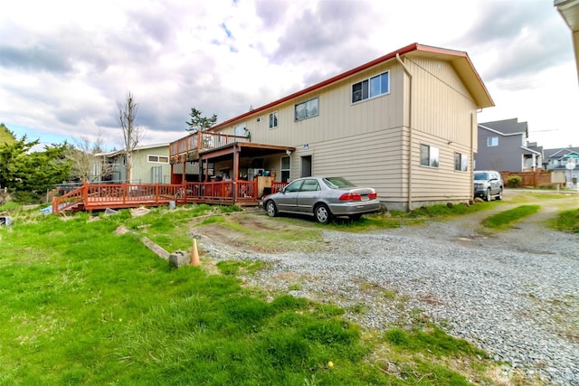 rear view of house with driveway and a deck