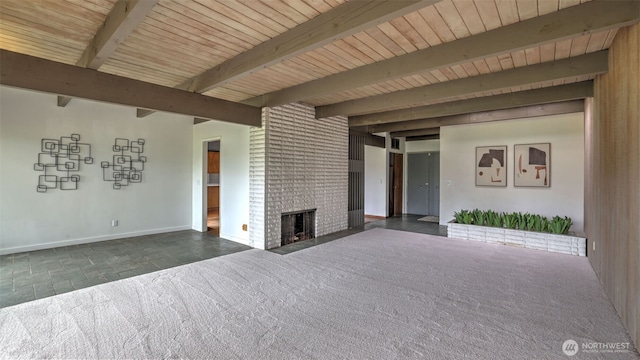 unfurnished living room with carpet floors, baseboards, beamed ceiling, and a fireplace