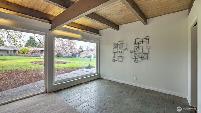doorway with baseboards, wood ceiling, beamed ceiling, and stone tile floors
