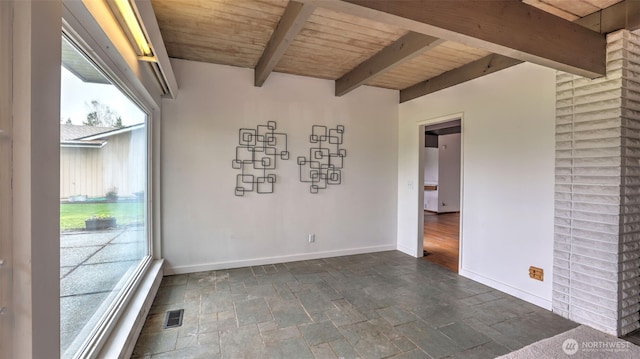 spare room featuring baseboards, visible vents, wood ceiling, and stone finish flooring