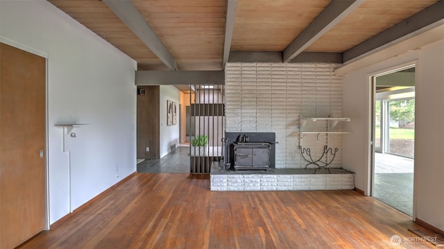 unfurnished living room featuring wood finished floors, a wood stove, wooden ceiling, and beam ceiling