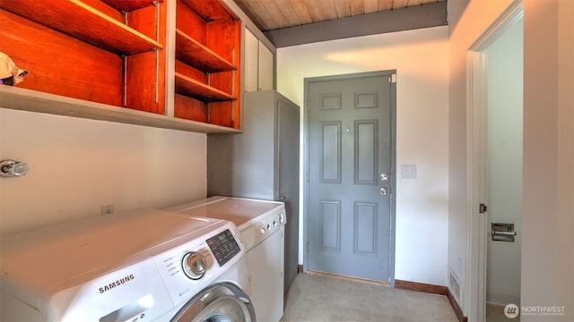 laundry area with baseboards, separate washer and dryer, wooden ceiling, and laundry area