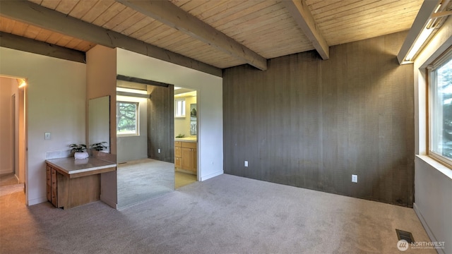 bedroom with visible vents, beam ceiling, ensuite bath, wooden ceiling, and light colored carpet