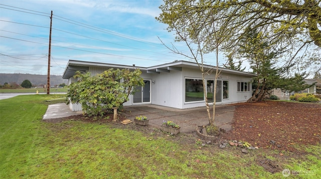 back of property featuring a patio and a yard