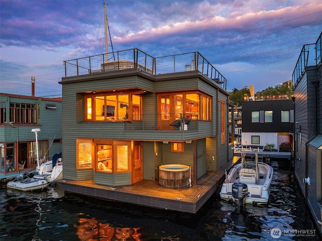 back of house at dusk featuring a balcony