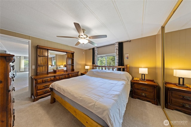 carpeted bedroom with a textured ceiling and a ceiling fan