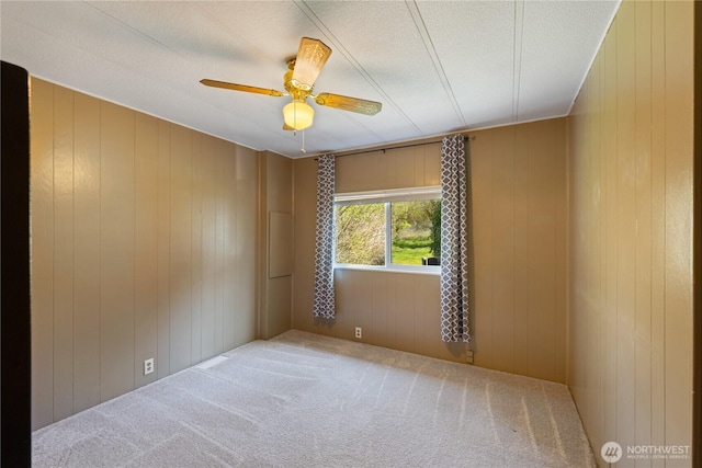 carpeted spare room featuring a ceiling fan and a textured ceiling