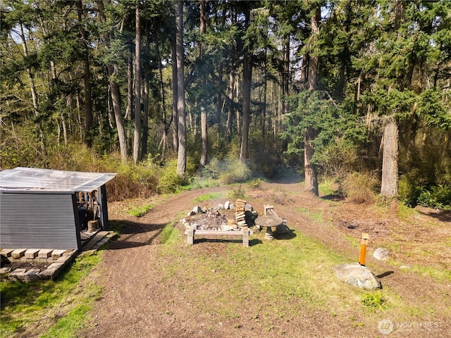 view of yard with a view of trees and an outdoor structure