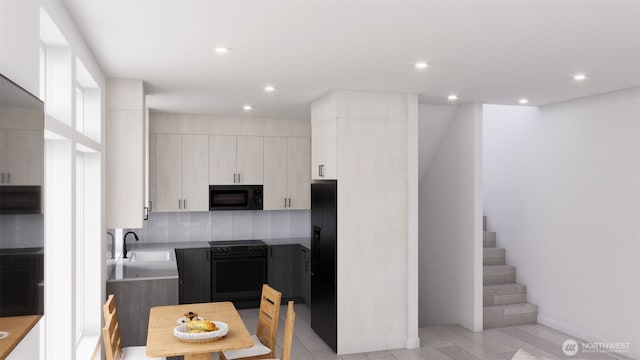 kitchen featuring white cabinets, recessed lighting, a sink, and black appliances