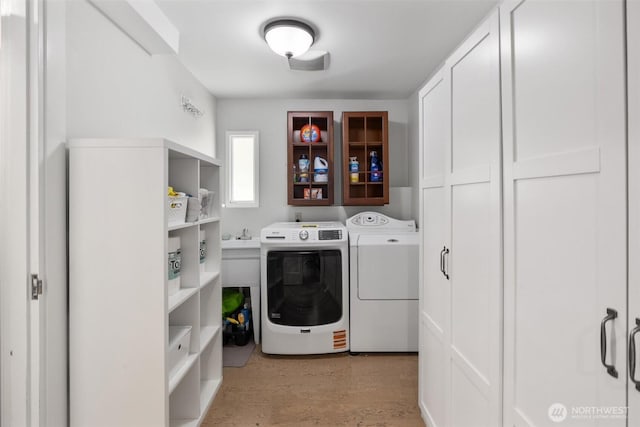 washroom with cabinet space, light wood finished floors, and independent washer and dryer