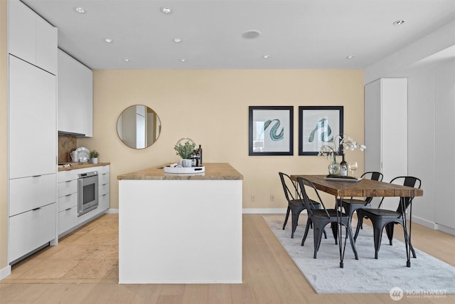 dining area with recessed lighting, baseboards, and light wood-style floors