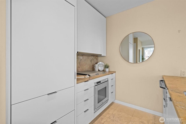 kitchen with white fridge, white cabinets, modern cabinets, and wall oven