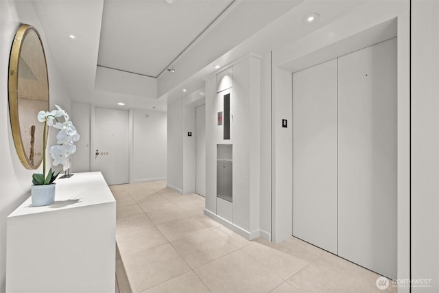 hallway featuring recessed lighting, light tile patterned flooring, and elevator