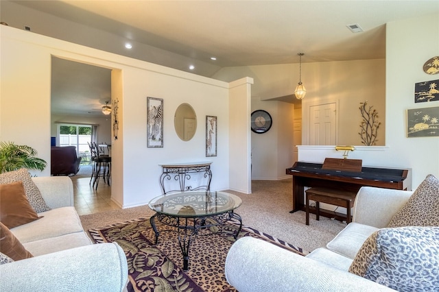 living area featuring lofted ceiling, ceiling fan, baseboards, and visible vents