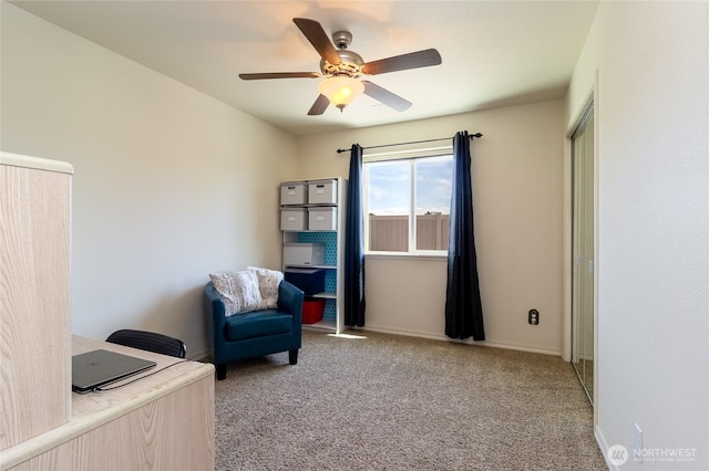 sitting room with baseboards, ceiling fan, and carpet
