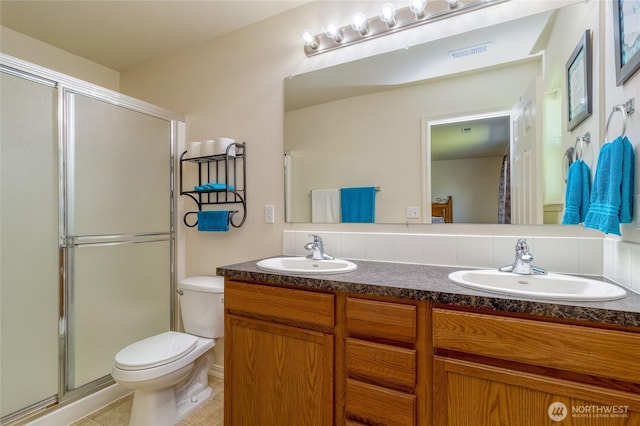 bathroom with a sink, toilet, a shower stall, and visible vents