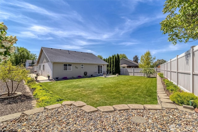 rear view of property featuring a patio, a lawn, and a fenced backyard