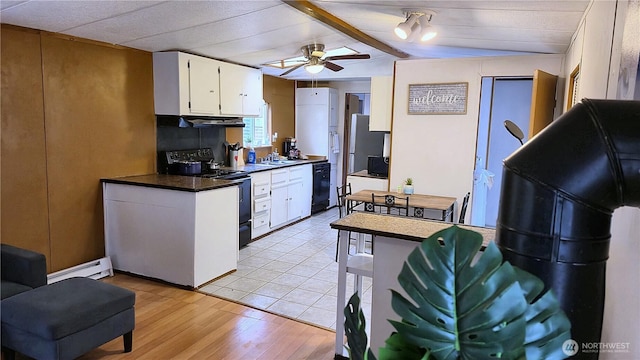 116 Galleon Loop NE, Ocean Shores, WA 98569 - kitchen with black appliances, a baseboard radiator, extractor fan, dark countertops, and white cabinets