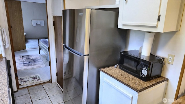 116 Galleon Loop NE, Ocean Shores, WA 98569 - kitchen featuring freestanding refrigerator, black microwave, light tile patterned floors, and white cabinetry